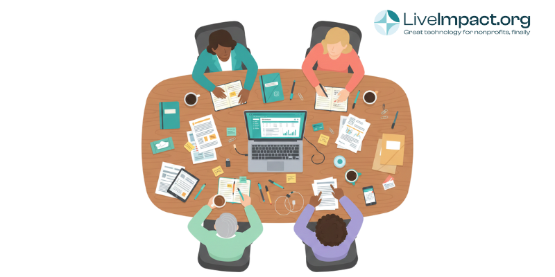 Small nonprofit team evaluating CRM software options on a laptop during a staff meeting.